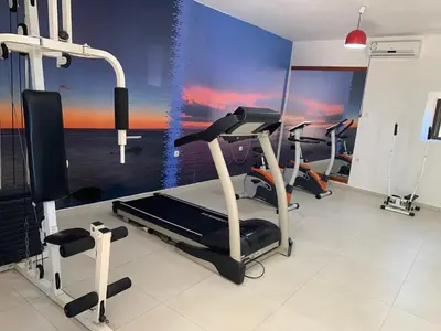 a gym with three tread machines and a view of the ocean at Hotel Palata Venezia in Ulcinj