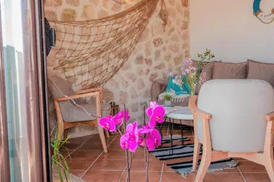 a room with a table and a chair and pink flowers at Apartments Bazar in Ulcinj