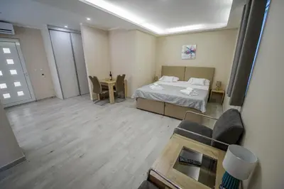 a bedroom with a bed and a table and chairs at Apartment Vrutak in Kotor