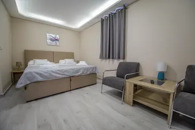 a bedroom with a bed and two chairs and a table at Apartment Vrutak in Kotor