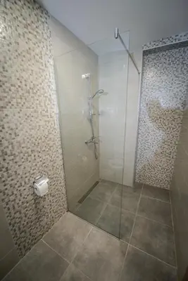 a bathroom with a shower with a glass door at Apartment Vrutak in Kotor