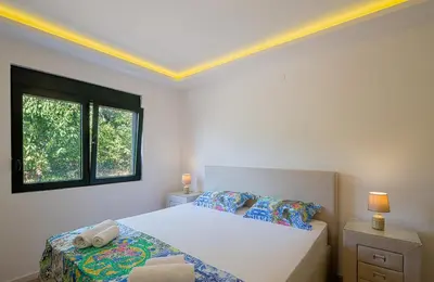 a white bedroom with a bed and a window at Villa Latina 2 in Budva
