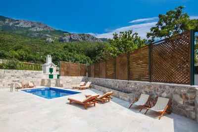 a patio with chairs and a pool and a fence at Villa Latina 2 in Budva