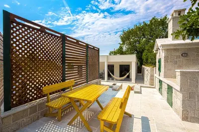 a yellow picnic table and two benches on a patio at Villa Latina 2 in Budva