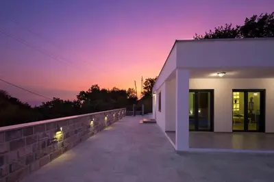 a white building with a sunset in the background at Villa Latina 2 in Budva