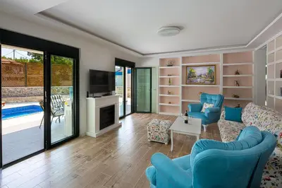 a living room with blue chairs and a tv at Villa Latina 2 in Budva