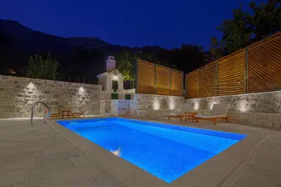 a swimming pool in a backyard at night at Villa Latina 2 in Budva