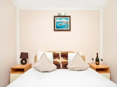a bedroom with a bed with white sheets and pillows at Apartments MIK5 - Famous Beach Jaz in Budva
