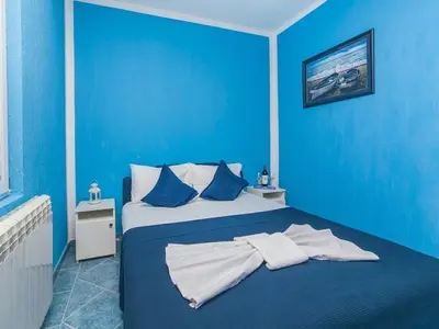 a blue bedroom with a large bed with blue walls at Apartments MIK5 - Famous Beach Jaz in Budva