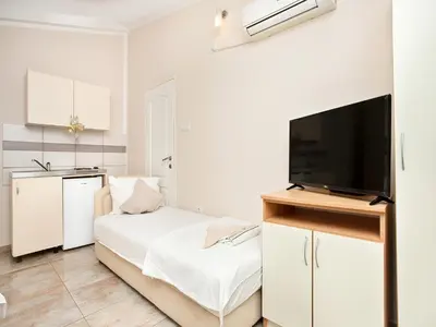 a bedroom with a bed and a flat screen tv at Apartments MIK5 - Famous Beach Jaz in Budva