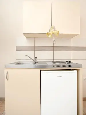 a white kitchen with a sink and a refrigerator at Apartments MIK5 - Famous Beach Jaz in Budva