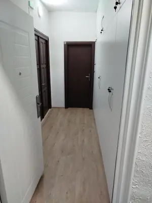 a hallway with a black door and a wooden floor at Guesthouse BiT Accommodation in Kotor