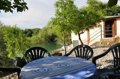 a blue table and chairs with a view of a river at Skadar Lake House Virpazar in Virpazar