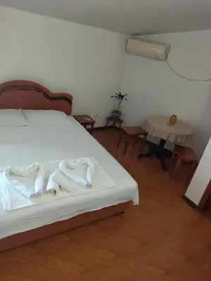 a bedroom with a bed with white sheets and a table at Apartment Klara in Bar