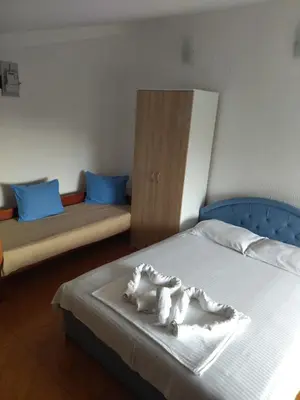 a bedroom with two beds and a wooden cabinet at Apartment Klara in Bar