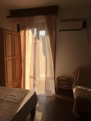 a bedroom with a bed and a window with curtains at Apartment Klara in Bar