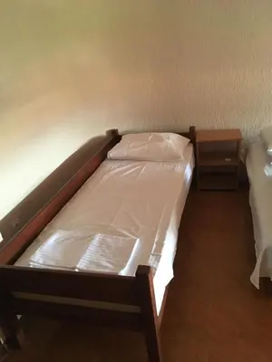 a small bed in a room with two tables at Apartment Klara in Bar