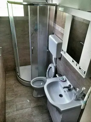 a bathroom with a shower and a toilet and a sink at Apartment Podkosljun in Budva