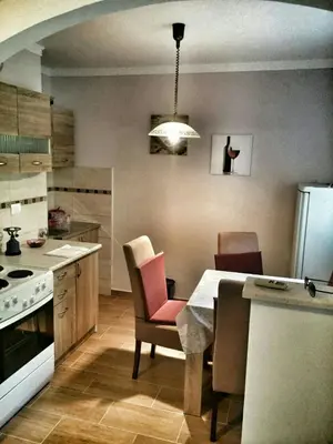 a kitchen with a table and chairs in a kitchen at Apartment Podkosljun in Budva