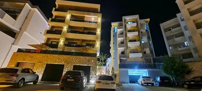 a parking lot with cars parked in front of a building at Ambassador & Ambassador Lux Apartments in Ulcinj