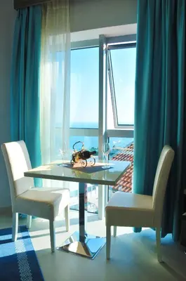 a glass table with two chairs and a window at Ambassador & Ambassador Lux Apartments in Ulcinj