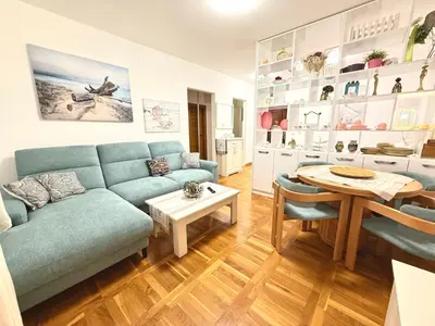 a living room with a blue couch and a table at Varja 2 Apartment in Sveti Stefan