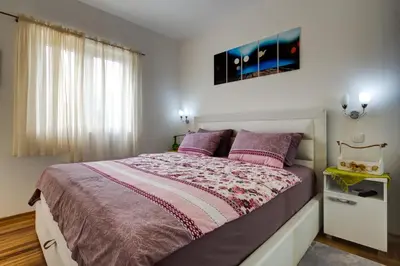 a bedroom with a large bed with purple pillows at Varja 2 Apartment in Sveti Stefan