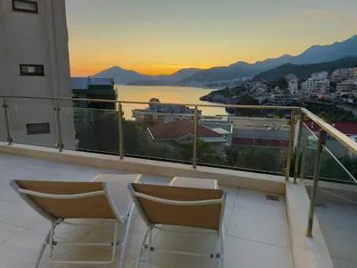 a balcony with two chairs and a view of a city at Varja 2 Apartment in Sveti Stefan