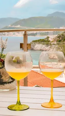 two wine glasses sitting on top of a table at Varja 2 Apartment in Sveti Stefan