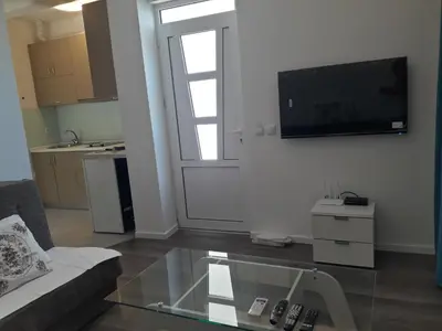a living room with a couch and a tv on a wall at Apartments Stojanovic in Ulcinj