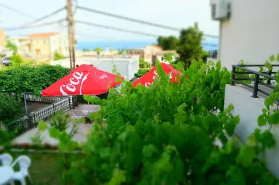 two cocacola umbrellas sitting in a garden at Apartments Stojanovic in Ulcinj