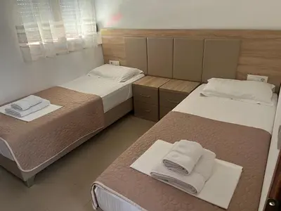 a bedroom with two beds with towels on them at Kollari Apartments in Ulcinj