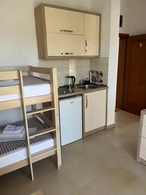 a small kitchen with a bunk bed and a sink at Kollari Apartments in Ulcinj