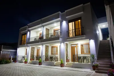 a large white building with stairs and balconies at night at Kollari Apartments in Ulcinj