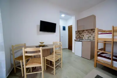 a small room with a table and a bunk bed at Kollari Apartments in Ulcinj