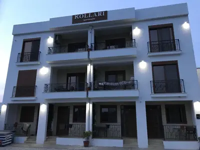 a white building with a sign on it at Kollari Apartments in Ulcinj