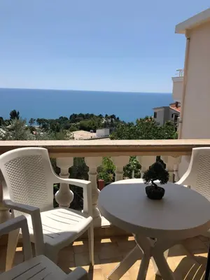 a balcony with a table and chairs and the ocean at Apartments Onyx in Ulcinj