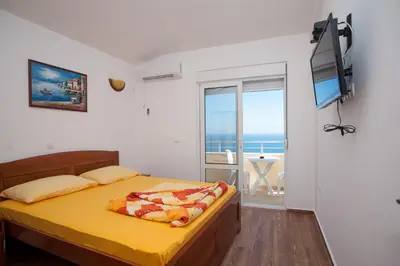 a bedroom with a yellow bed with a view of the ocean at Apartments Onyx in Ulcinj