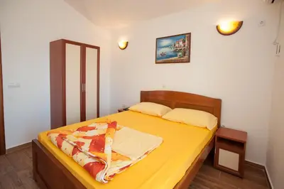 a bedroom with a bed with a yellow bedspread at Apartments Onyx in Ulcinj