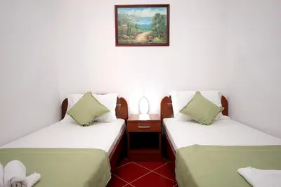 a room with two beds and a picture on the wall at Apartments Centar Sutomore in Sutomore