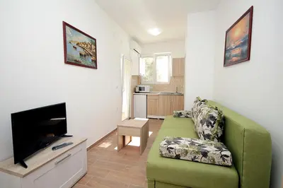 a living room with a green couch and a flat screen tv at Apartments Centar Sutomore in Sutomore