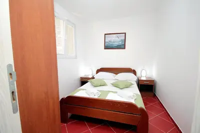 a bedroom with a bed with two nightstands and a bed sidx sidx sidx at Apartments Centar Sutomore in Sutomore