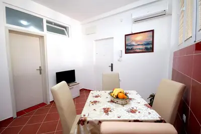 a dining room with a table with a bowl of fruit on it at Apartments Centar Sutomore in Sutomore