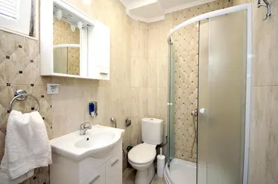 a bathroom with a toilet and a sink and a shower at Apartments Centar Sutomore in Sutomore