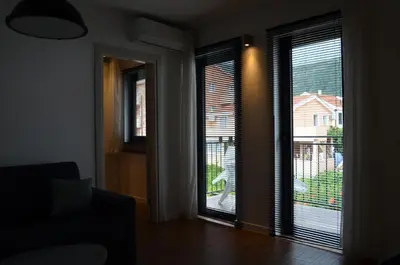a living room with two windows and a view of a house at Casablanca Apartments in Budva