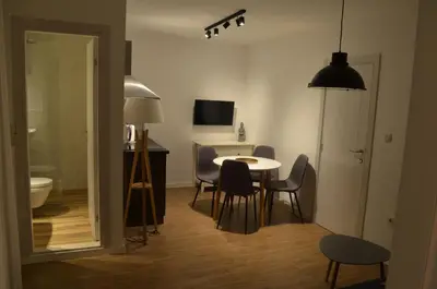 a room with a table and chairs and a television at Casablanca Apartments in Budva