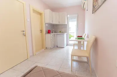 a small kitchen with a table and a table and chairs at Apartments Vjera Petrovac in Petrovac na Moru