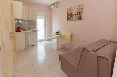 a living room with a couch and a kitchen at Apartments Vjera Petrovac in Petrovac na Moru