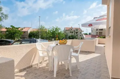 a table and chairs with a bowl of fruit on it at Apartments Vjera Petrovac in Petrovac na Moru