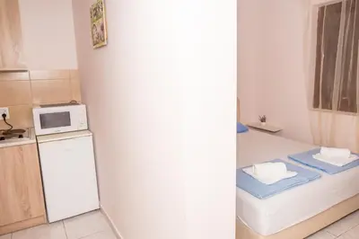 a small kitchen with a refrigerator and a microwave at Apartments Vjera Petrovac in Petrovac na Moru
